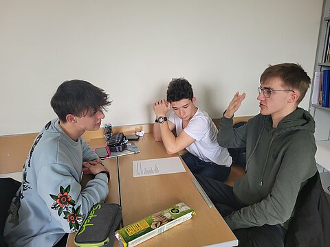 3 Jugendliche diskutieren in der Schule
